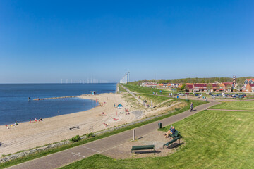 People on a bench overlooking the beach in Urk, Netherlands - obrazy, fototapety, plakaty