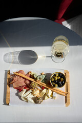 Background of salami, smoked sausage and assortment of cheese. On a black stone background. Free space for your text.