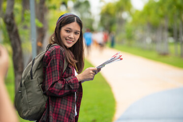 A young hipster tourist is looking at a map to get the right direction.