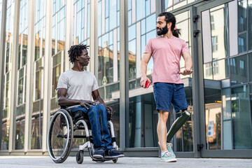 Two diverse friends having some disabilities walking in the city, people on wheel chair and...