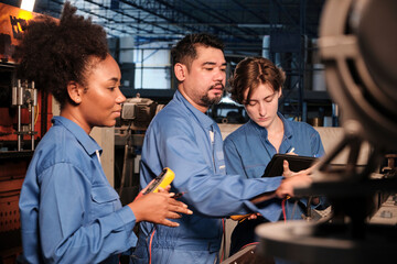 Multiracial professional industry engineer teams in safety uniforms work by inspecting machines' voltage current, checking, and maintaining at manufacture factory, electric system service occupations.