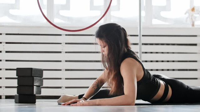 Fitness - a young woman gymnast doing yoga exercises