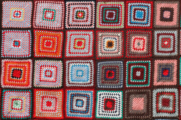 Detail of a crocheted patchwork multicolor wool blanket. - obrazy, fototapety, plakaty