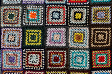 Detail of a crocheted patchwork multicolor wool blanket.