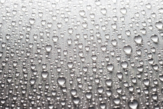 Raindrops on a gray flat texture of steel surface