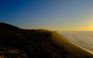 Fototapeta na wymiar twilight time by the ocean bay, hill at the ocean