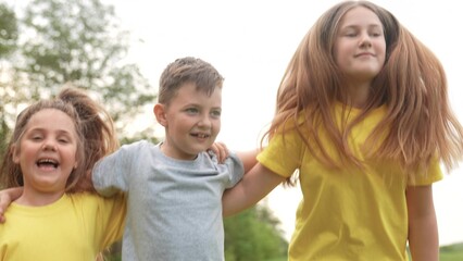 kids in the park. group of children a hugging rejoices and jumping in the park in nature outdoors. happy family kids in the park. children playing in the park fun in summer. happy family outdoors