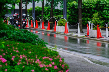 赤いカラーコーンと雨の街角