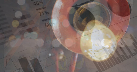 Image of graphs and financial data over warehouse light