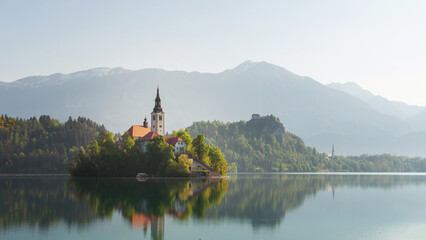 Fototapeta na wymiar Alpine Bled lake in Slovenia, amazing nature and scenic landscape with church on island and castle on a cliff.