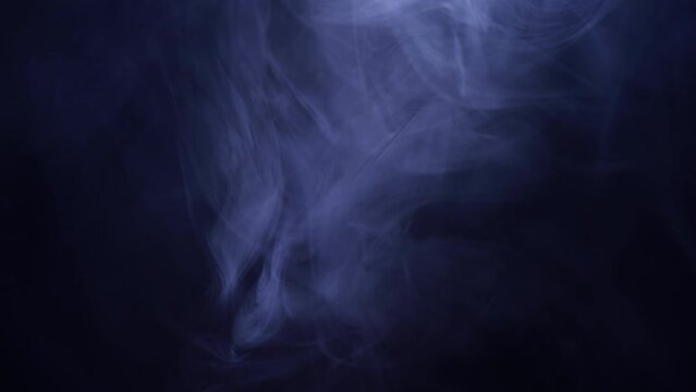 Smoke on black background in slow motion. Smoke billowing over a black background.