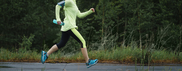 Adult runner woman runs in the park jogging.
