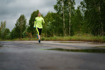 Adult runner woman runs in the park jogging.