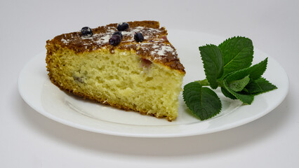 piece of blueberry cake ,pie on a white plate with green mint