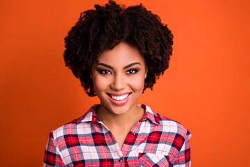 Obraz na płótnie Canvas Photo of adorable charming woman wear plaid shirt smiling isolated orange color background