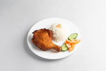 asian deep fried fresh crispy kampong chicken rice with cucumber and tomato in white background...