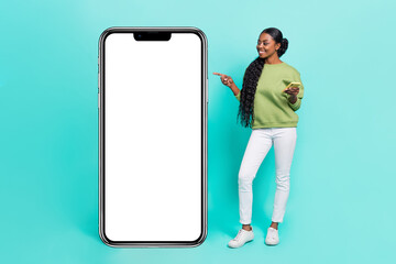 Full length body size view of attractive cheerful girl using device showing ad copy space isolated...