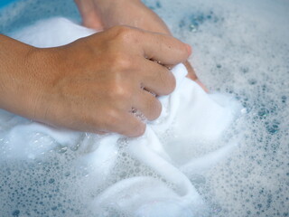 Woman hands washing white clothes in sink. closeup photo, blurred.