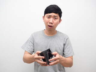 Asian man feel shocked about no money holding empty wallet in hand