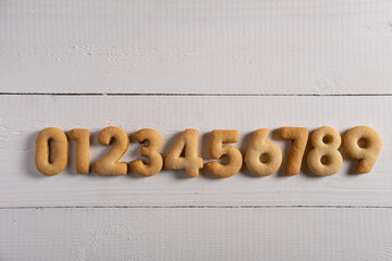 Numbers from 0 to 9 made from biscuits on a wooden background