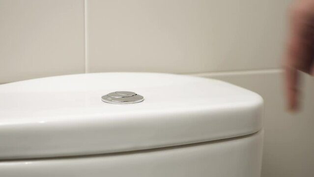 4k video footage of a hand pressing a button to flush water in WC