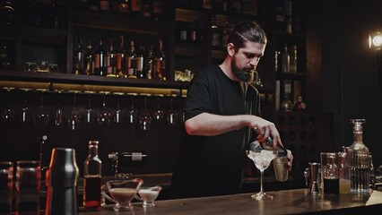Professional bartender fills cocktail shaker with ice