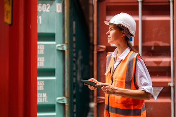 Female manager using tablet working at container yard.