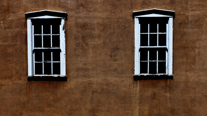 Two windows in a pueblo style building