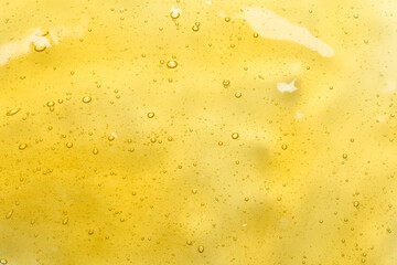 Golden honey or cosmetic gel serum with bubbles background texture top view - 508617229