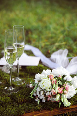 Wedding glasses and a bouquet on a blurred background