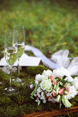 Wedding glasses and a bouquet on a blurred background