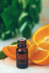 Orange essential oil in a small bottle. Selective focus.