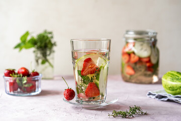 Fototapeta na wymiar Infused water with strawberry and meloncella that is hybrid of cucumber and melon, thyme, mint.