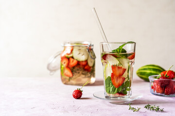 Infused water with strawberry and meloncella that is hybrid of cucumber and melon, thyme, mint. Copy space.