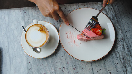 a girl cuts a piece of strawberry cake with a knife
