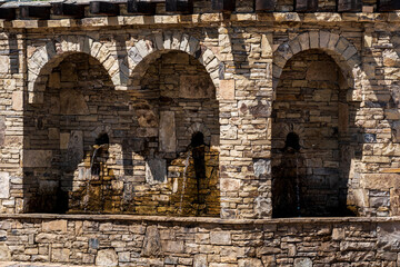 street drinking fountain in a natural stone arch