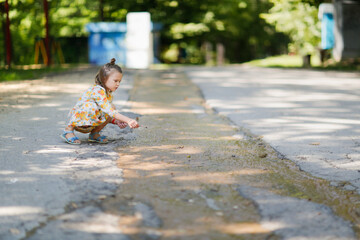 Cute european baby girl playing with a stream in the park