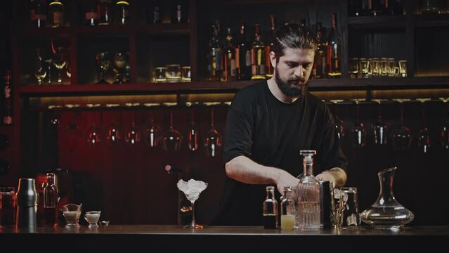 Bartender opens shaker and fills ice to create cocktail
