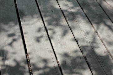 Background photo with an angular angle of wooden decking on the ground on a sunny day.