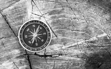 black and white photo of round compass as symbol of tourism with compass, travel with compass and...