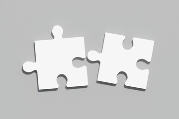 Two white puzzles on a gray background, the concept of joining or separating something