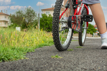 Fototapeta na wymiar bike and leg of child riding on asphalt road.