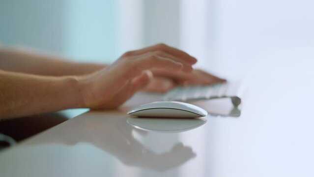 Worker hands holding mouse using wireless device at bright home office closeup.