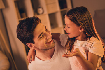 Naklejka premium Photo of adorable funny father small school girl spending time together talking indoors house home room