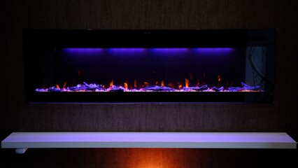 view on electric fireplace with artificial sparkling flame, decor for the interior, orange flame on...