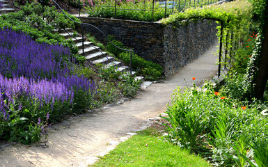 road cut into the slope. above and below the road is a stone dry wall. nature trail through the...