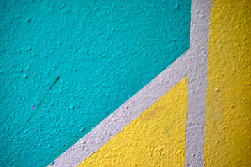 Fototapeta na wymiar A yellow and blue wall painted with stripes and a triangle