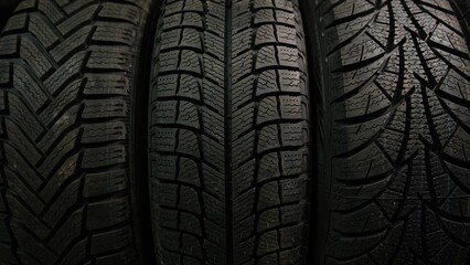 three Different Winter tires for cars with slow moving from down to the top on a shop stand