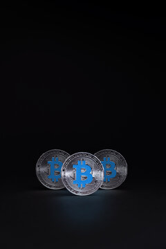 Silver Bitcoin coins currency. Crypto coin with logo on cyan colour, on a dark background. BTC International stock exchange.