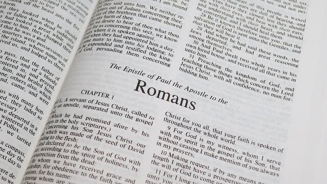 Close Up Shot of  Bible Page Turning to the book of Romans